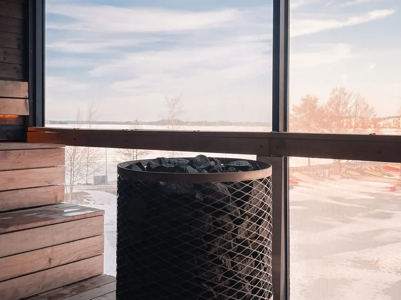 Sauna heater with stones inside a wooden sauna